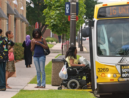 Black women including one using a wheelchair entering a bus
