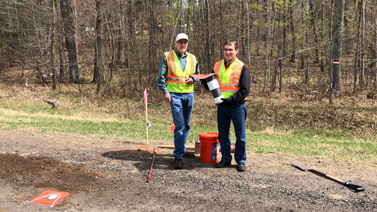 Researchers in the field holding runoff collection device
