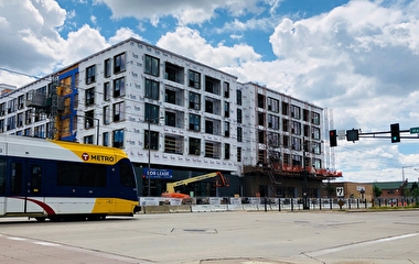 Light-rail train going by a building under construction