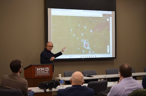 Tom Horan presenting in front of a map of Minnesota