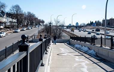 A person walking up a pedestrian crossing over I-94 in the Rondo neighboorhood