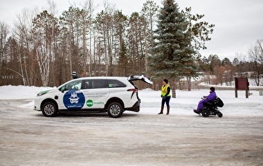 A person in a wheelchair waiting to board the GoMarti autonomous shuttle in winter