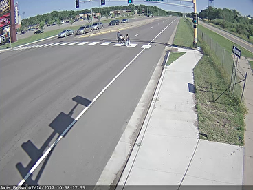 Pedestrians crossing a divided road at crosswalk