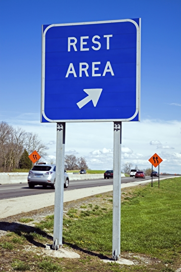 Blue rest area sign on the side of a freeway 